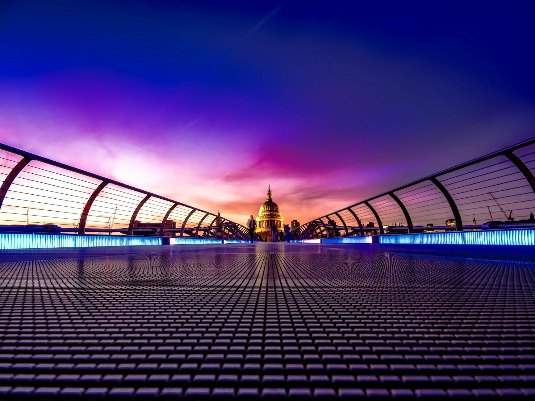 Captivating view of London’s Millennium Bridge at sunset with St. Paul’s Cathedral in the background.