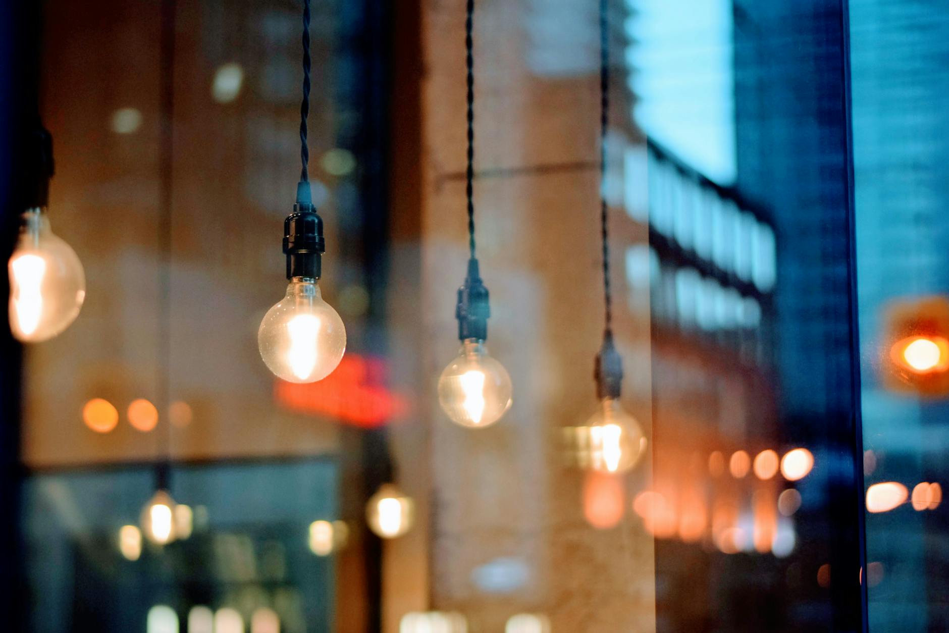 A creative shot of illuminated bulbs with city reflections, showcasing evening ambiance.