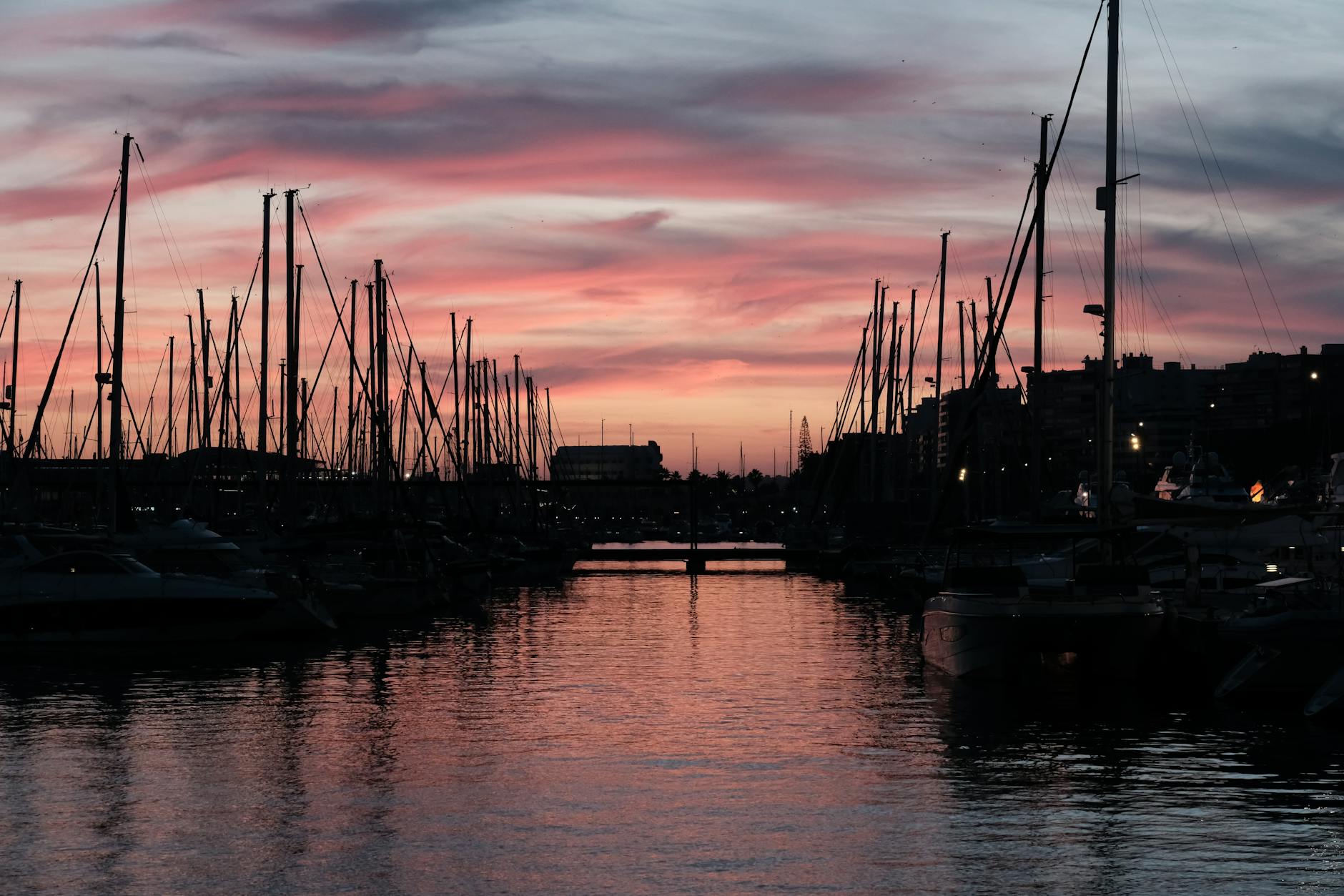 Beautiful sunset at Alicante harbor, featuring silhouetted boats and vibrant pink skies. Beautiful sunset at Alicante harbor, featuring silhouetted boats and vibrant pink skies.