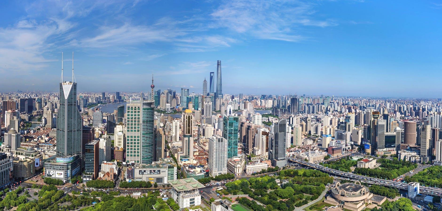 A stunning aerial view of Shanghai’s modern skyline with iconic skyscrapers under a clear blue sky.