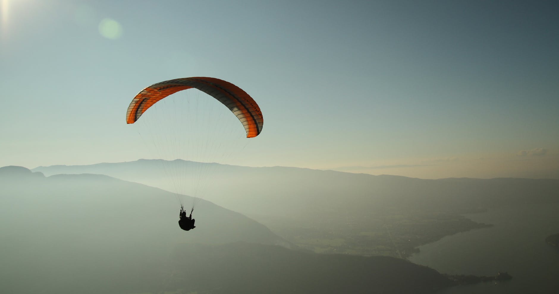 Experience the thrill of paragliding over the stunning Lake Annecy with breathtaking mountain views.