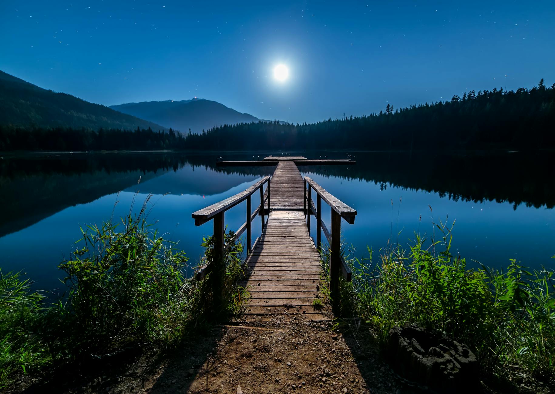 Discover tranquility at a moonlit dock in Whistler, BC, under a starry sky.