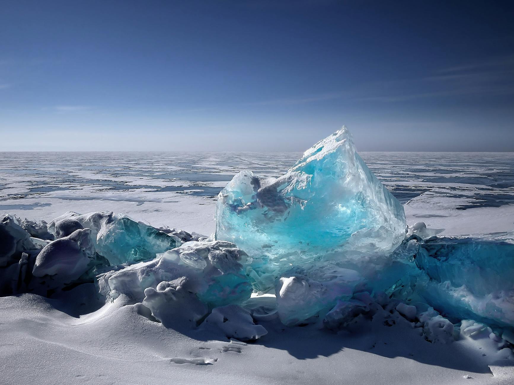 Captivating ice formation on a frozen lake under a bright blue sky during winter. Captivating ice formation on a frozen lake under a bright blue sky during winter.