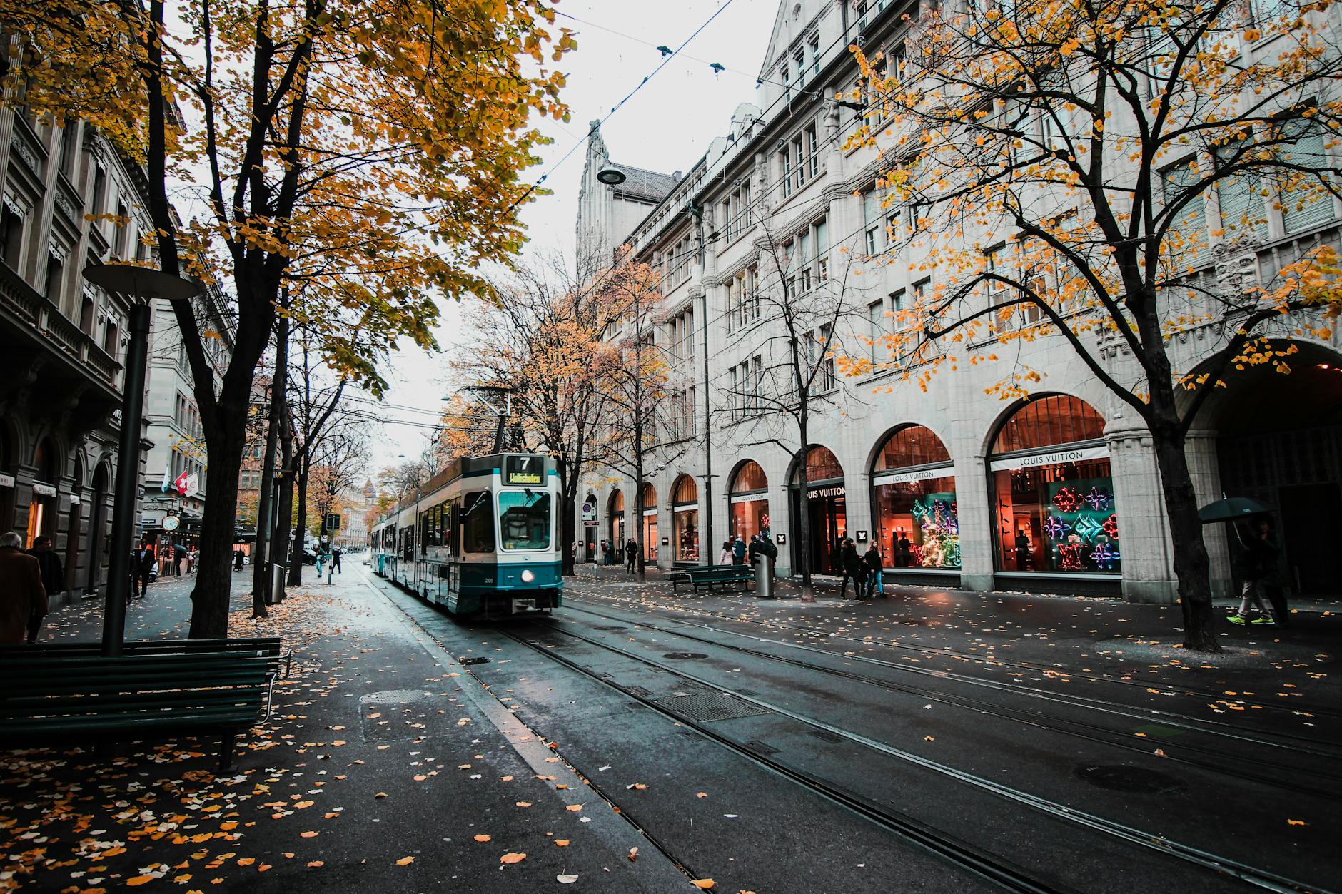 A tram travels down a leaf-strewn street in autumnal Zürich, Switzerland’s urban landscape. A tram travels down a leaf-strewn street in autumnal Zürich, Switzerland’s urban landscape.