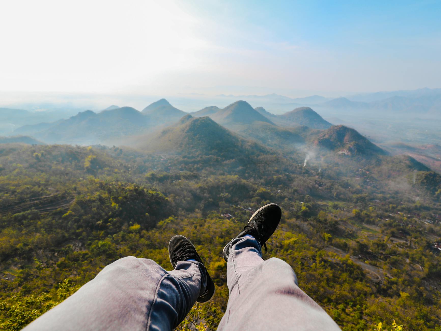 Feet dangling over the stunning landscape of Wonogiri Hills during sunrise, capturing the essence of Indonesian nature. Feet dangling over the stunning landscape of Wonogiri Hills during sunrise, capturing the essence of Indonesian nature.