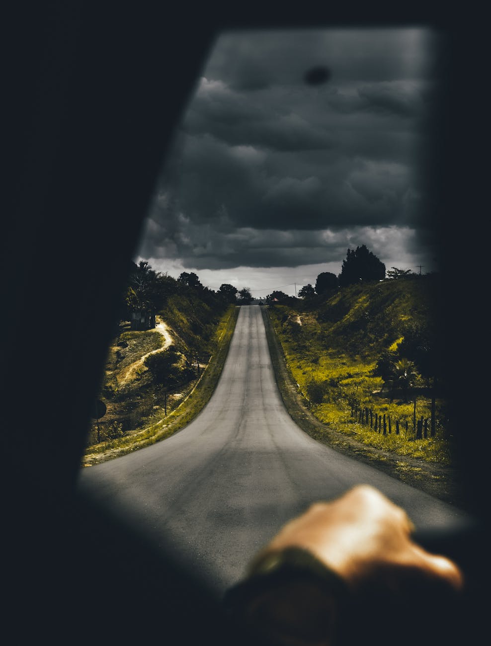 A moody drive on an open road with dark clouds overhead, capturing a sense of adventure and solitude.