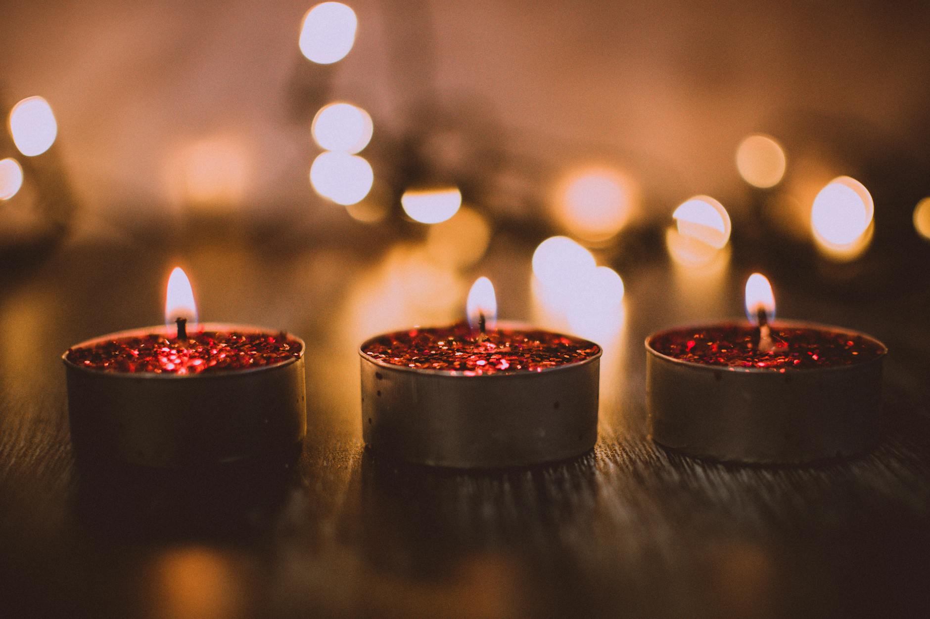 Three red glittery candles burning warmly, evoking a cozy ambiance perfect for celebrations. Three red glittery candles burning warmly, evoking a cozy ambiance perfect for celebrations.