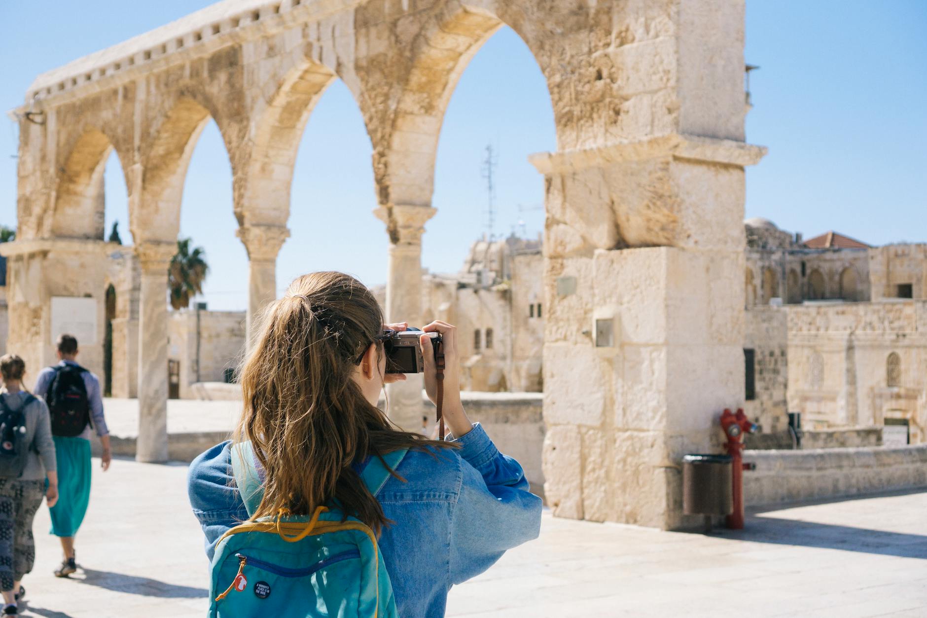 A tourist photographs the ancient stone arches in Jerusalem’s Old Town, capturing the essence of travel and history. A tourist photographs the ancient stone arches in Jerusalem’s Old Town, capturing the essence of travel and history.