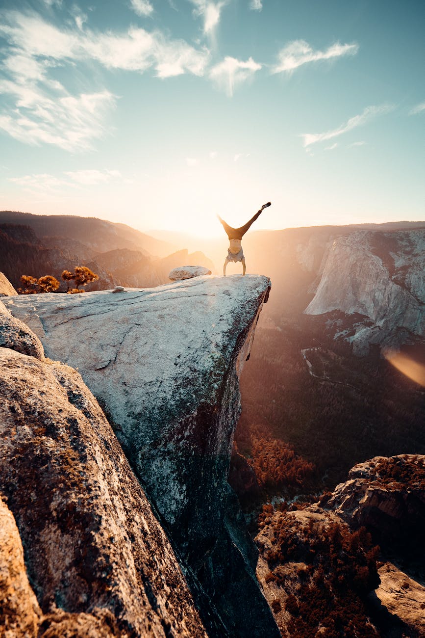 Thrilling handstand on a cliff edge in Yosemite National Park during sunset.