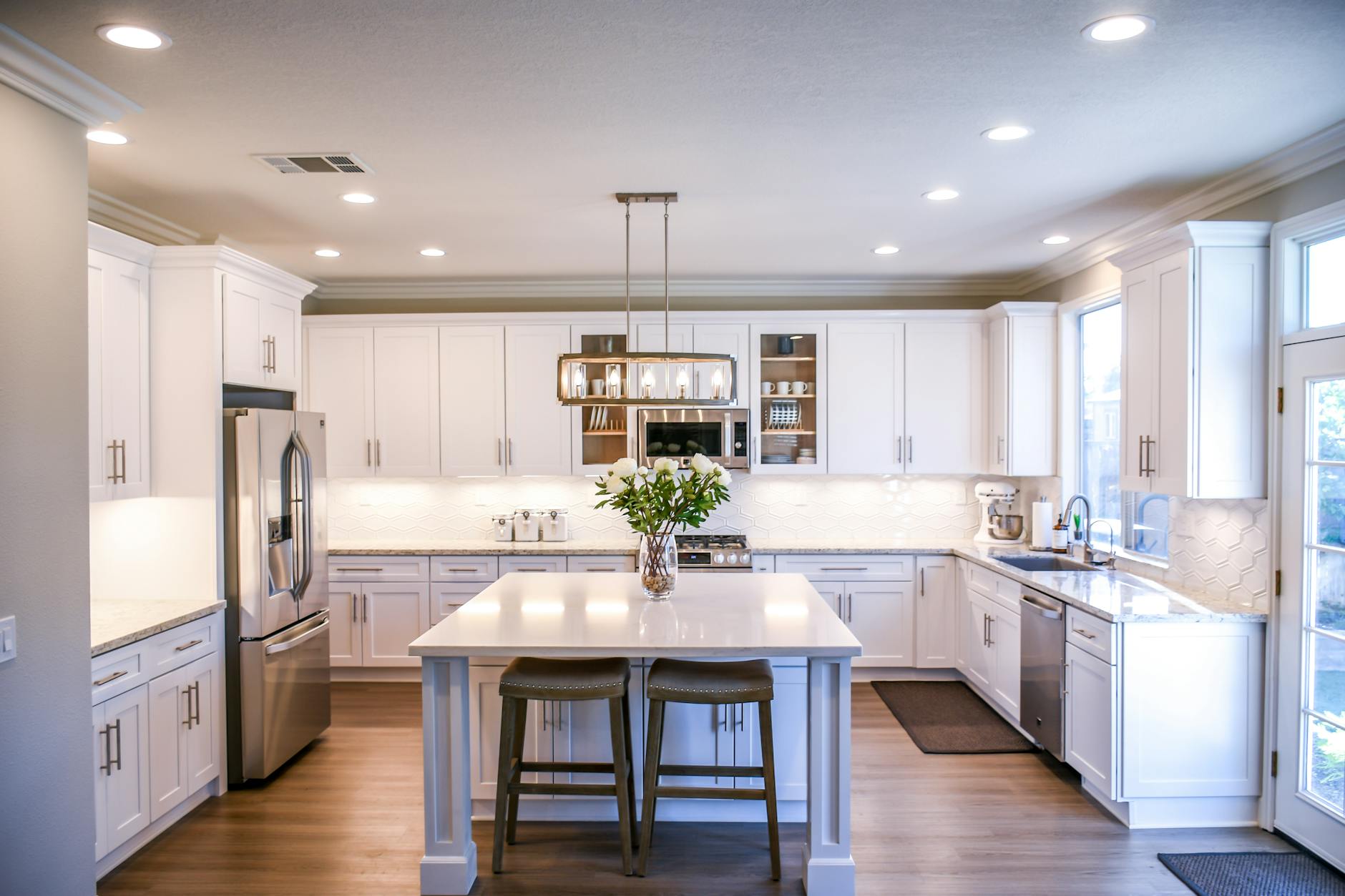 Spacious and elegant kitchen featuring white cabinetry, island, and stainless steel appliances. Spacious and elegant kitchen featuring white cabinetry, island, and stainless steel appliances.