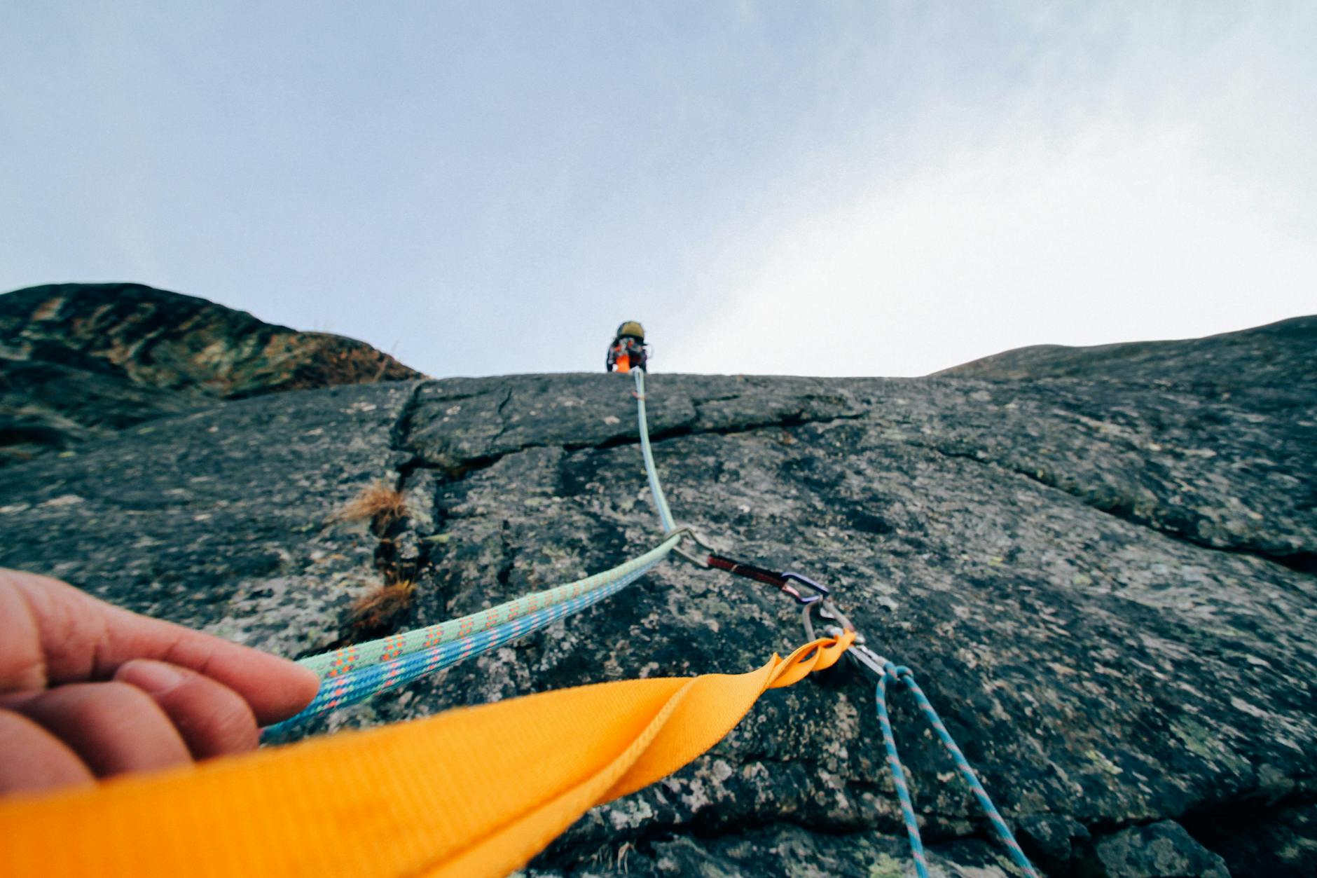 Capture the thrill of rock climbing with this dynamic low-angle shot showcasing determination and teamwork.