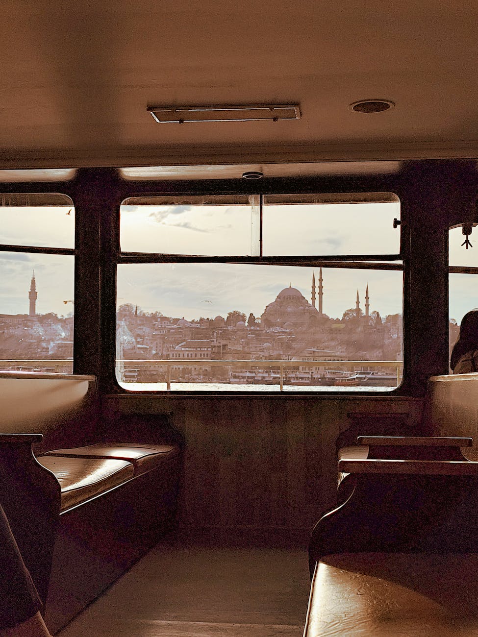 Scenic view of Istanbul skyline with mosques seen from a ferry window, capturing urban beauty. Scenic view of Istanbul skyline with mosques seen from a ferry window, capturing urban beauty.