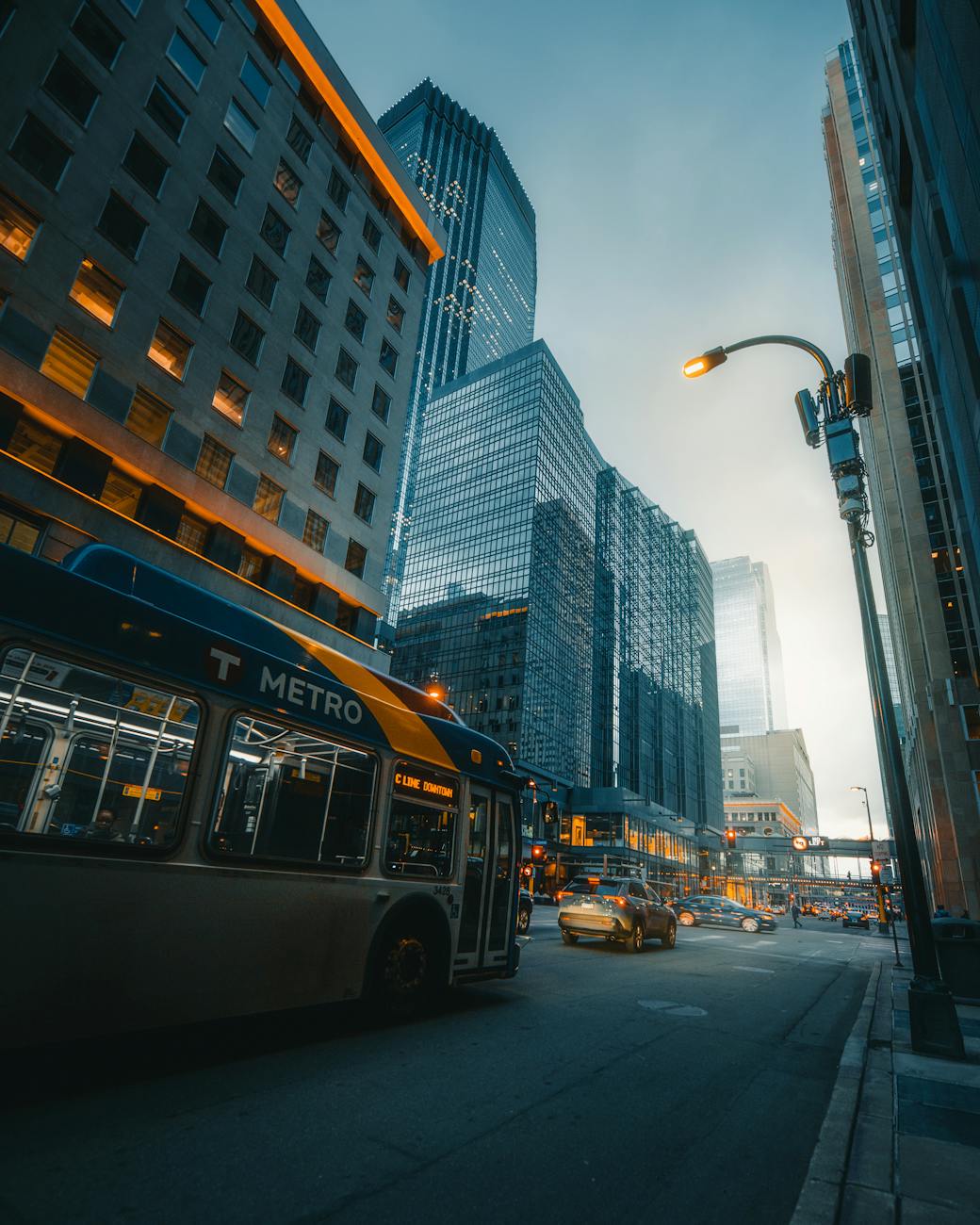 Dynamic street view of downtown Minneapolis showcasing metro bus and skyscrapers in a bustling urban environment.