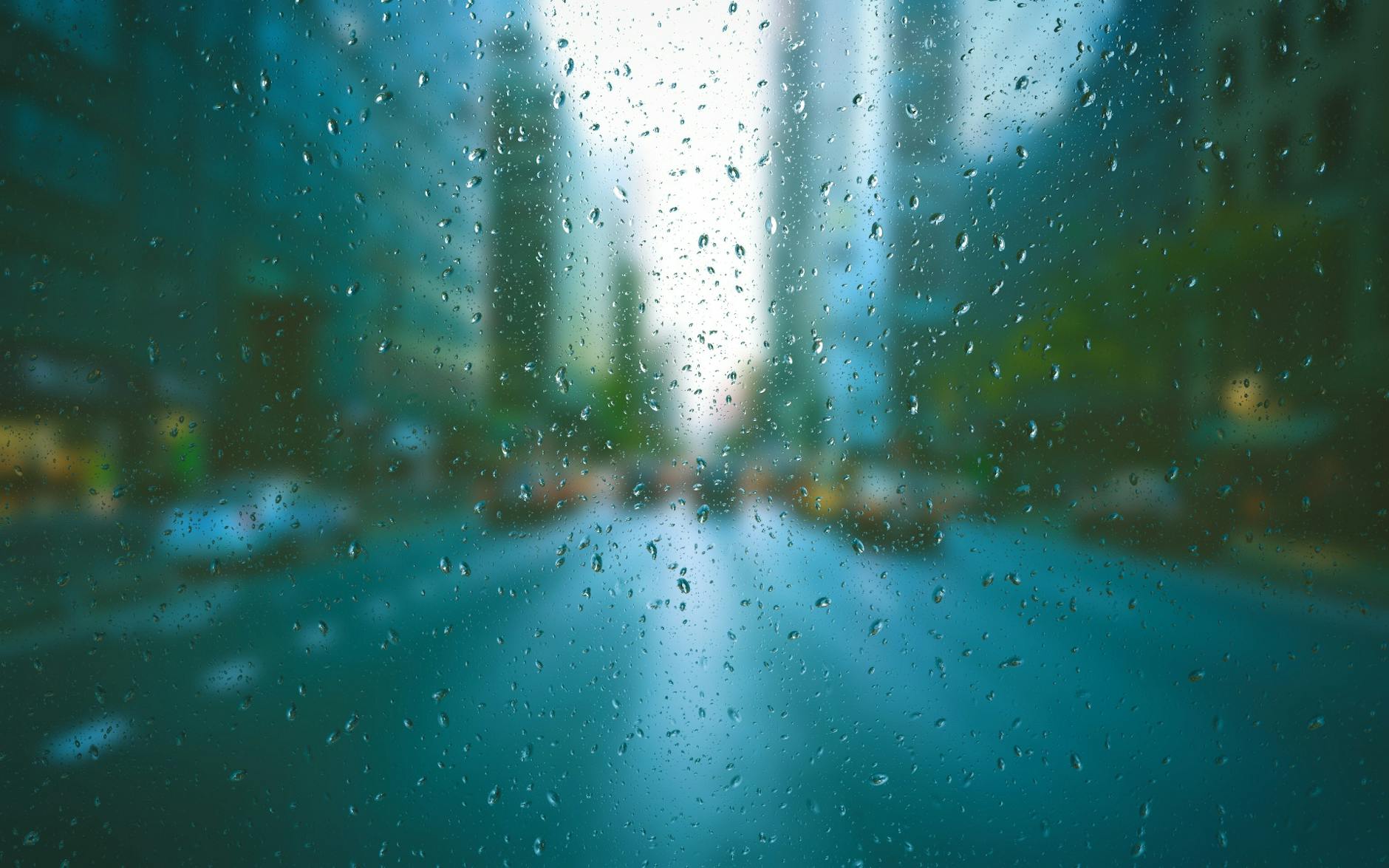 Blurred city scene through raindrop-covered window, creating a tranquil urban mood. Blurred city scene through raindrop-covered window, creating a tranquil urban mood.